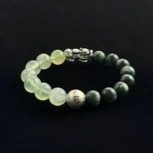 Feng Shui crystal bracelet with dark green Green Ghost beads, translucent Grape Stone (Prehnite) beads, a silver Pixiu wealth charm, and a silver mantra bead on a black background.